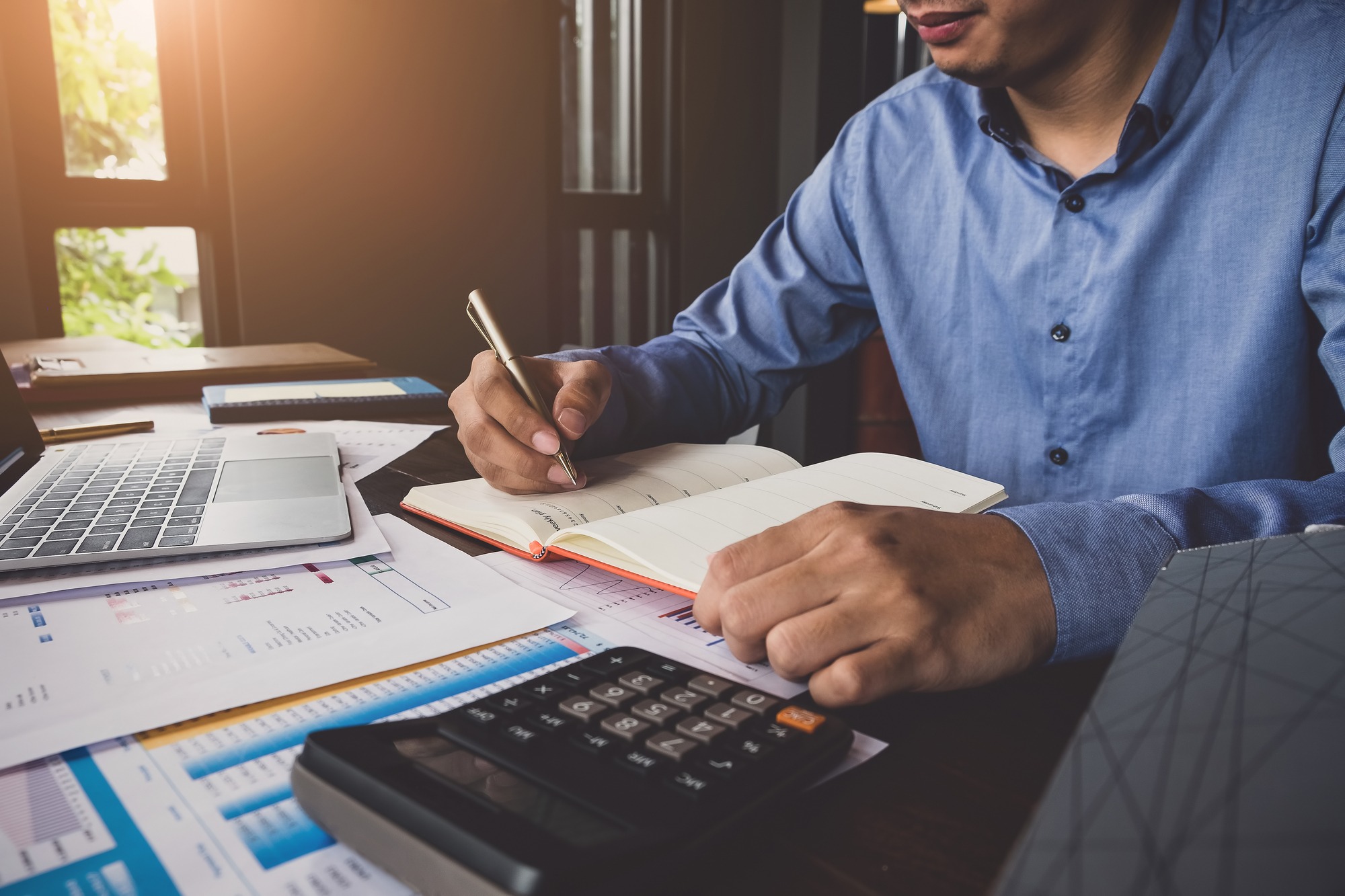 Bookkeeper accounting Concepts, Male use notebook, pen , calculator and computer laptop to working financial